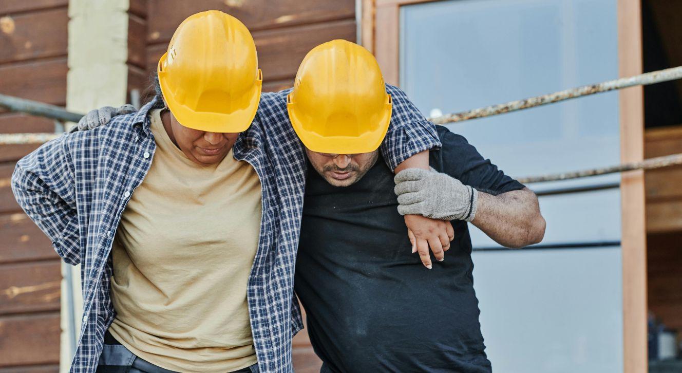 Paramedics assisting an injured construction worker at a job site