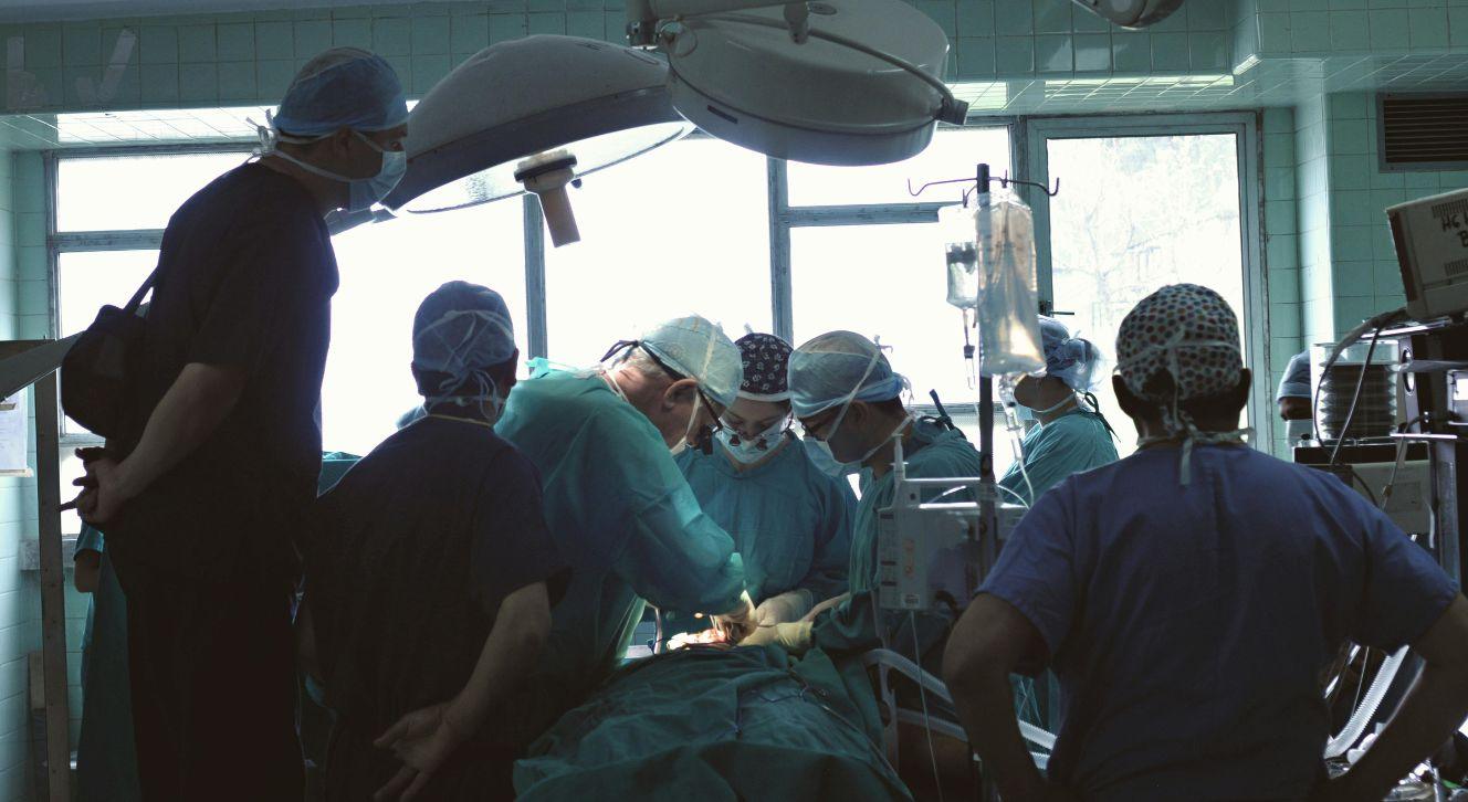 Surgeons performing an operation in a hospital operating room.