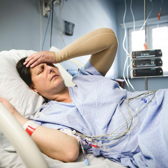 Patient holding their head in pain