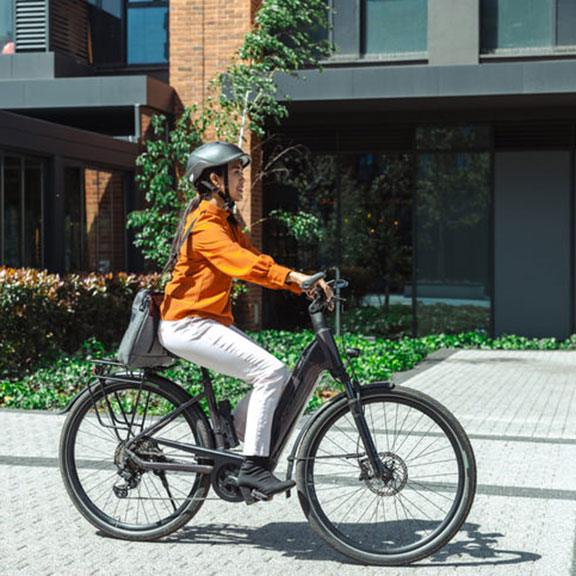 Woman with a helmet on riding an e-bike. Woman with a helmet on riding an e-bike.