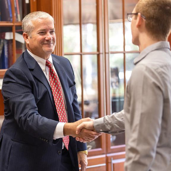 Lance giving a firm handshake to a client