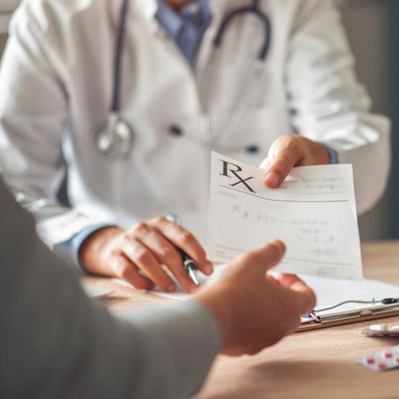 Man handing over Rx sheet to their patient