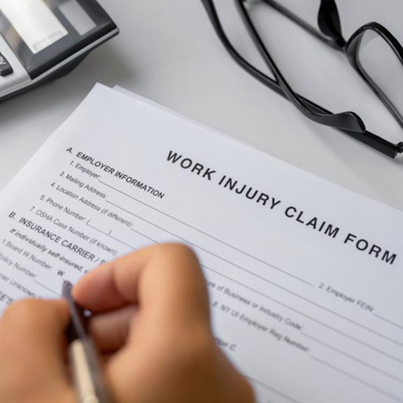 Work Injury Claim Form being signed by a person